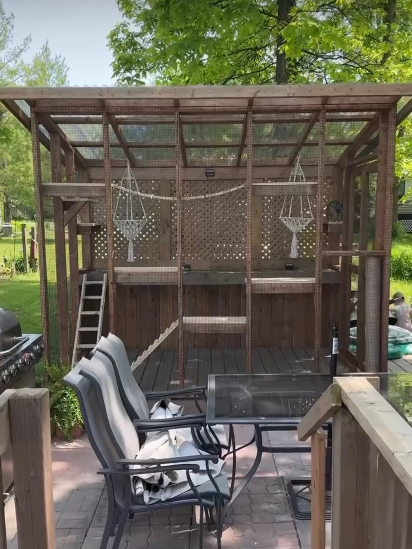 Cedar catio with macramé hanging planters and outdoor seating area